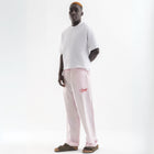 Unisex wide-leg striped cotton pants in pink and white, relaxed slouchy fit, modeled with casual summer outfit.