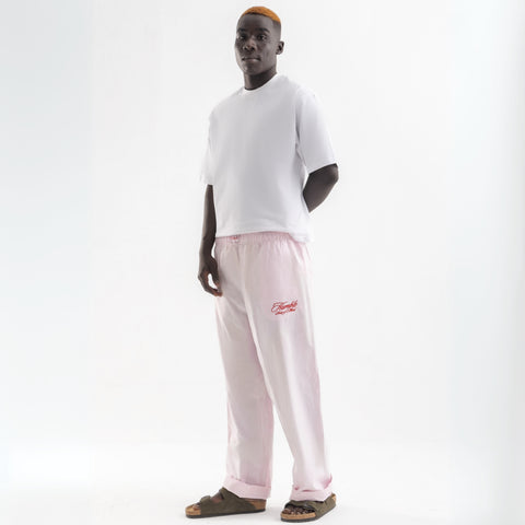 Unisex wide-leg striped cotton pants in pink and white, relaxed slouchy fit, modeled with casual summer outfit.