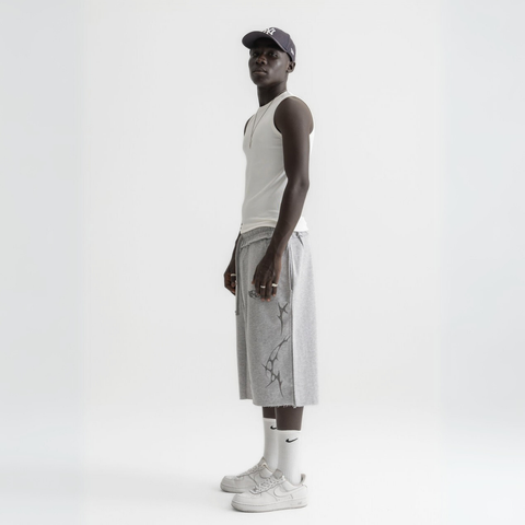 Unisex grey long shorts made of 100% cotton with raw hem edges and chunky waistband.