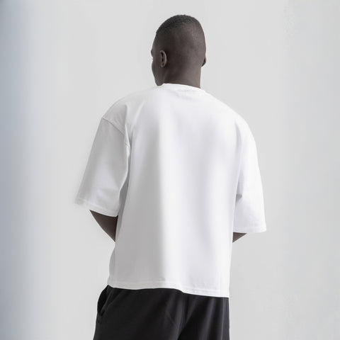 Men’s white box-fit oversized tee, front view showcasing relaxed fit and minimalist design.