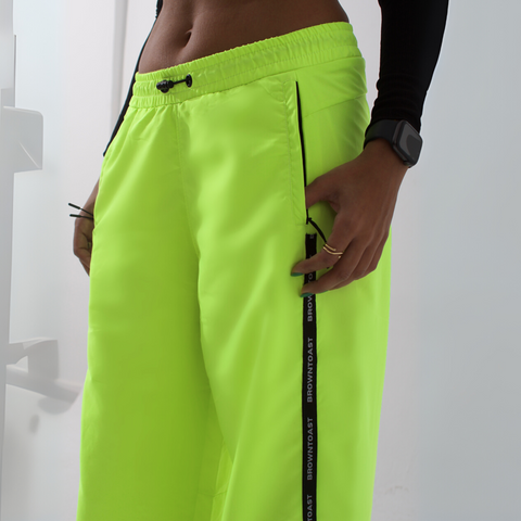 Unisex wide-fit waterproof pants in soft polyester with side stripe logo and adjustable waistband.