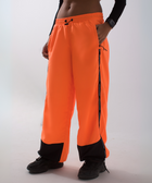 Unisex wide-fit waterproof pants in soft polyester with side stripe logo and adjustable waistband.