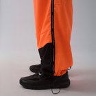 Unisex wide-fit waterproof pants in soft polyester with side stripe logo and adjustable waistband.