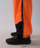 Unisex wide-fit waterproof pants in soft polyester with side stripe logo and adjustable waistband.