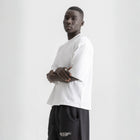 Men’s white box-fit oversized tee, front view showcasing relaxed fit and minimalist design.