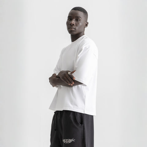 Men’s white box-fit oversized tee, front view showcasing relaxed fit and minimalist design.